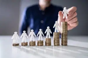 Direct sales MLM Compensation Plan Growth MLM Compensation Plans. Human Hand Placing Human Figure On Increasing Stacked Coins